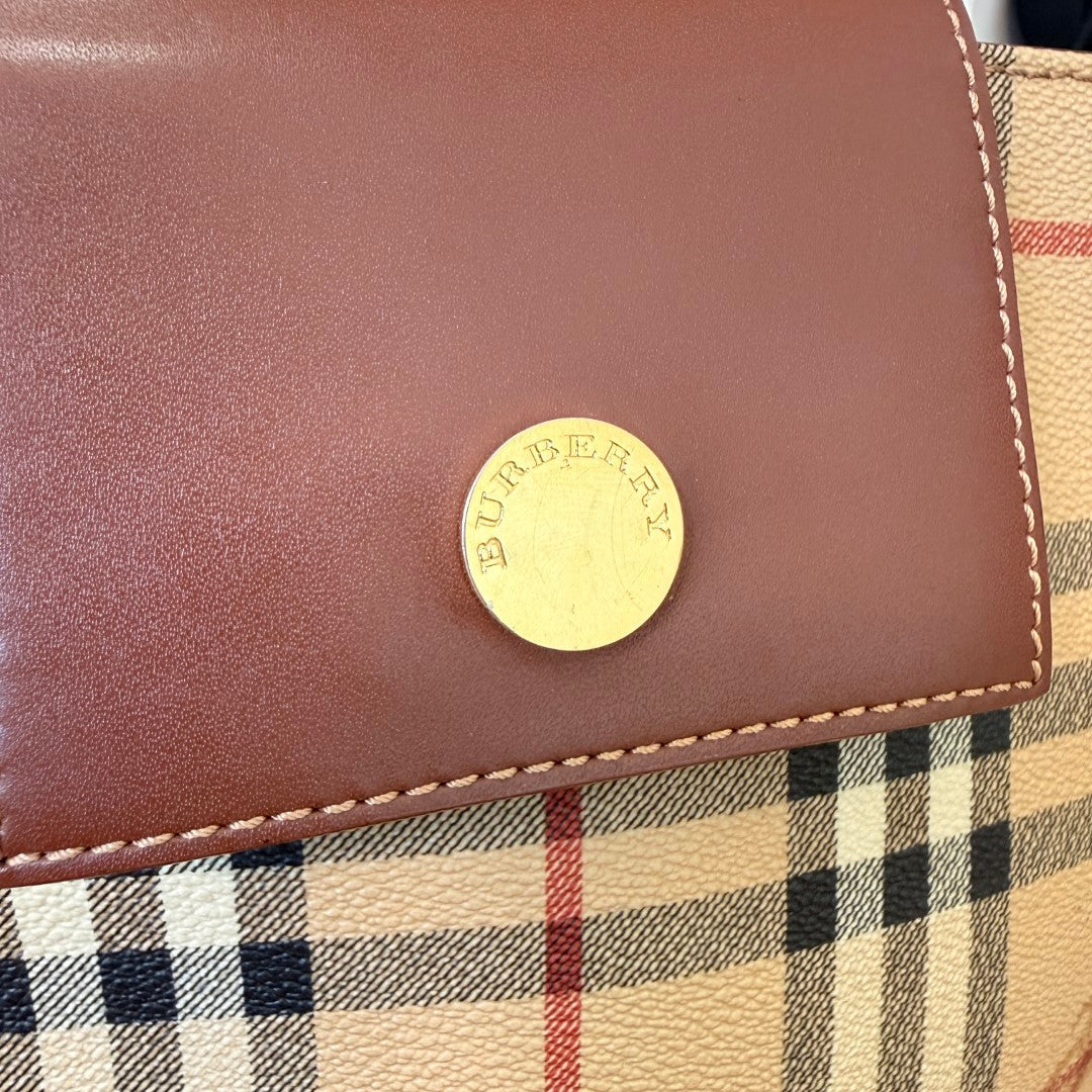 Luxe Vault Burberry House Check medium tote bag featuring a dark brown leather flap with a gold logo snap button