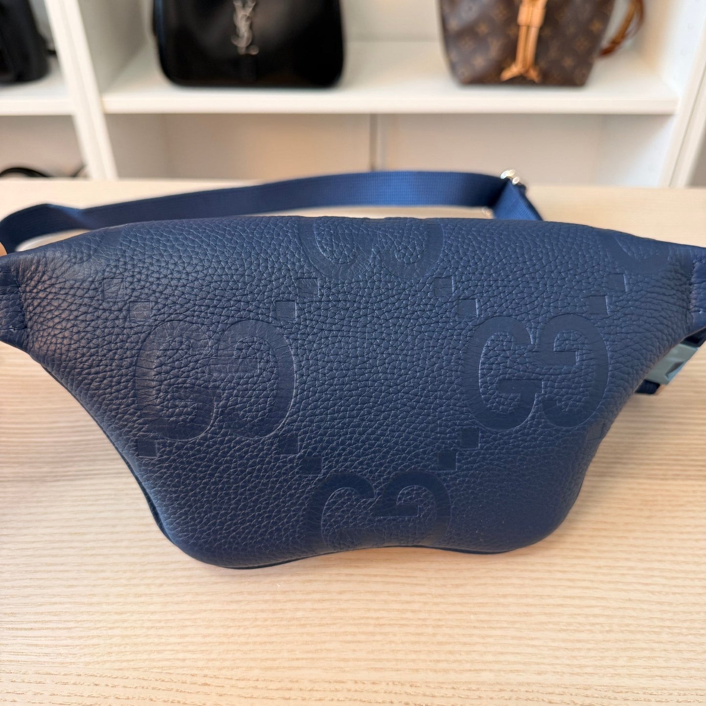 Luxe Vault blue Gucci Jumbo GG embossed leather belt bag with adjustable strap and silver hardware.