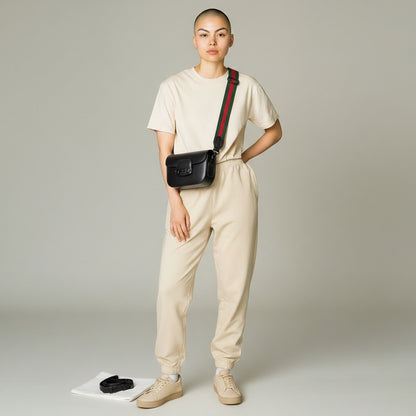 Luxe Vault model wearing a black Gucci Monochrome Horsebit 1955 shoulder bag with a green and red web strap