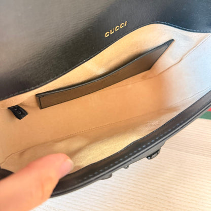 Interior view of Luxe Vault Gucci Monochrome Horsebit 1955 shoulder bag featuring a beige fabric lining and gold logo.