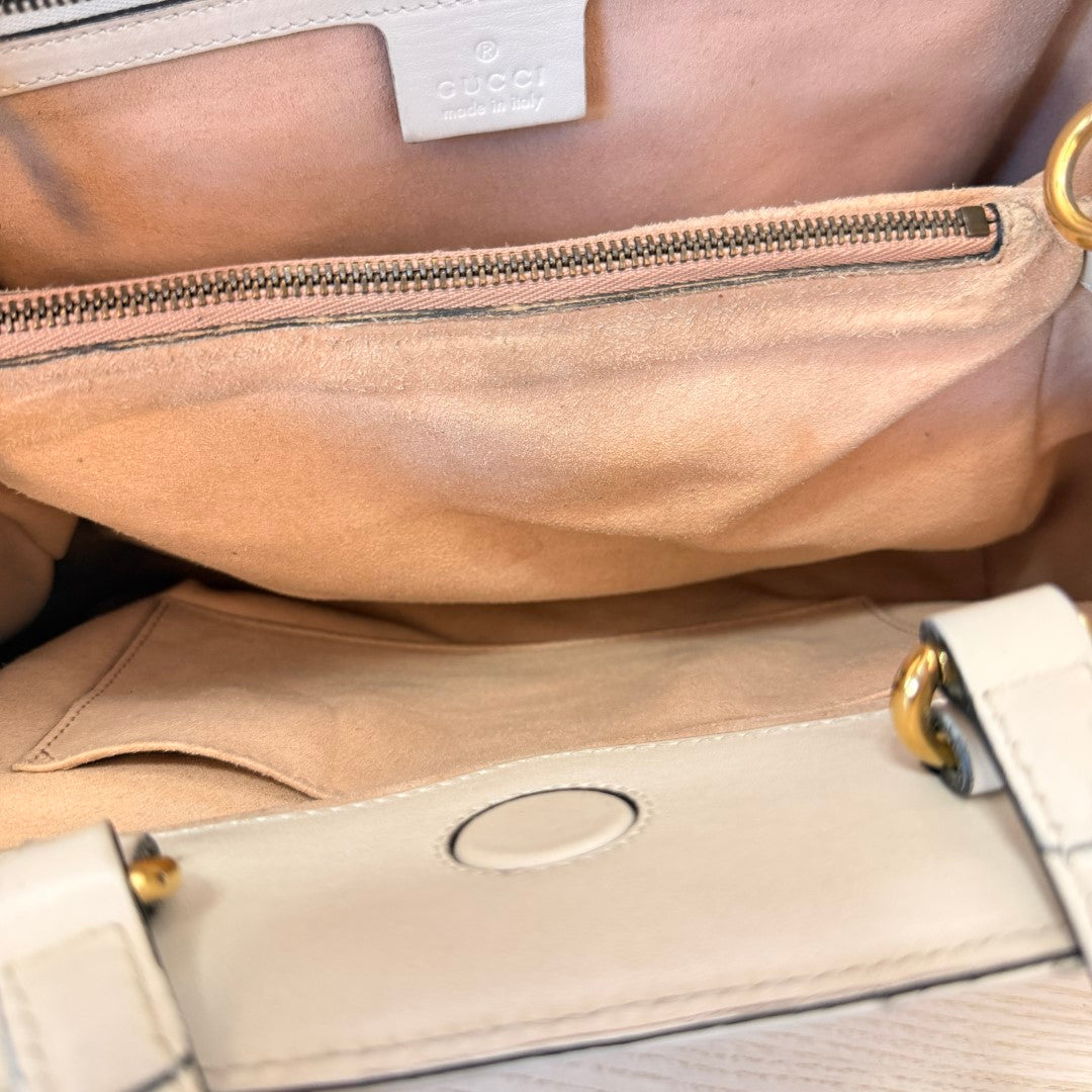 Luxe Vault interior view of a white Gucci GG Marmont tote bag showing the suede lining and zip pocket