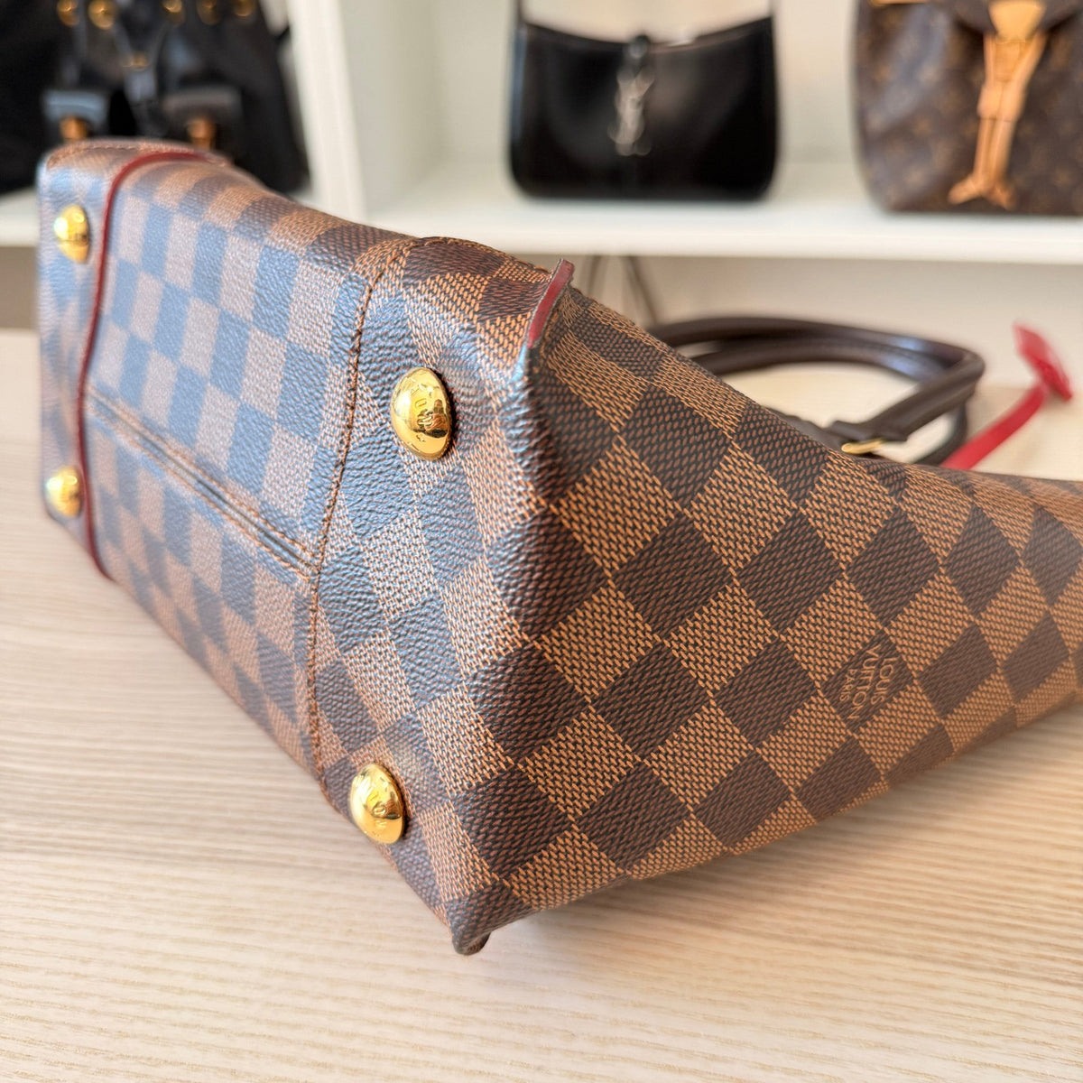 Luxe Vault Louis Vuitton Caissa PM bag in Damier Ebene canvas showing the base with protective gold-tone metal feet