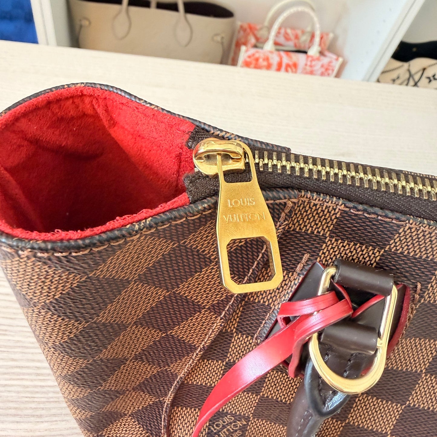 Luxe Vault Louis Vuitton Caissa PM handbag in Damier Ebene canvas with gold hardware and vibrant red interior lining