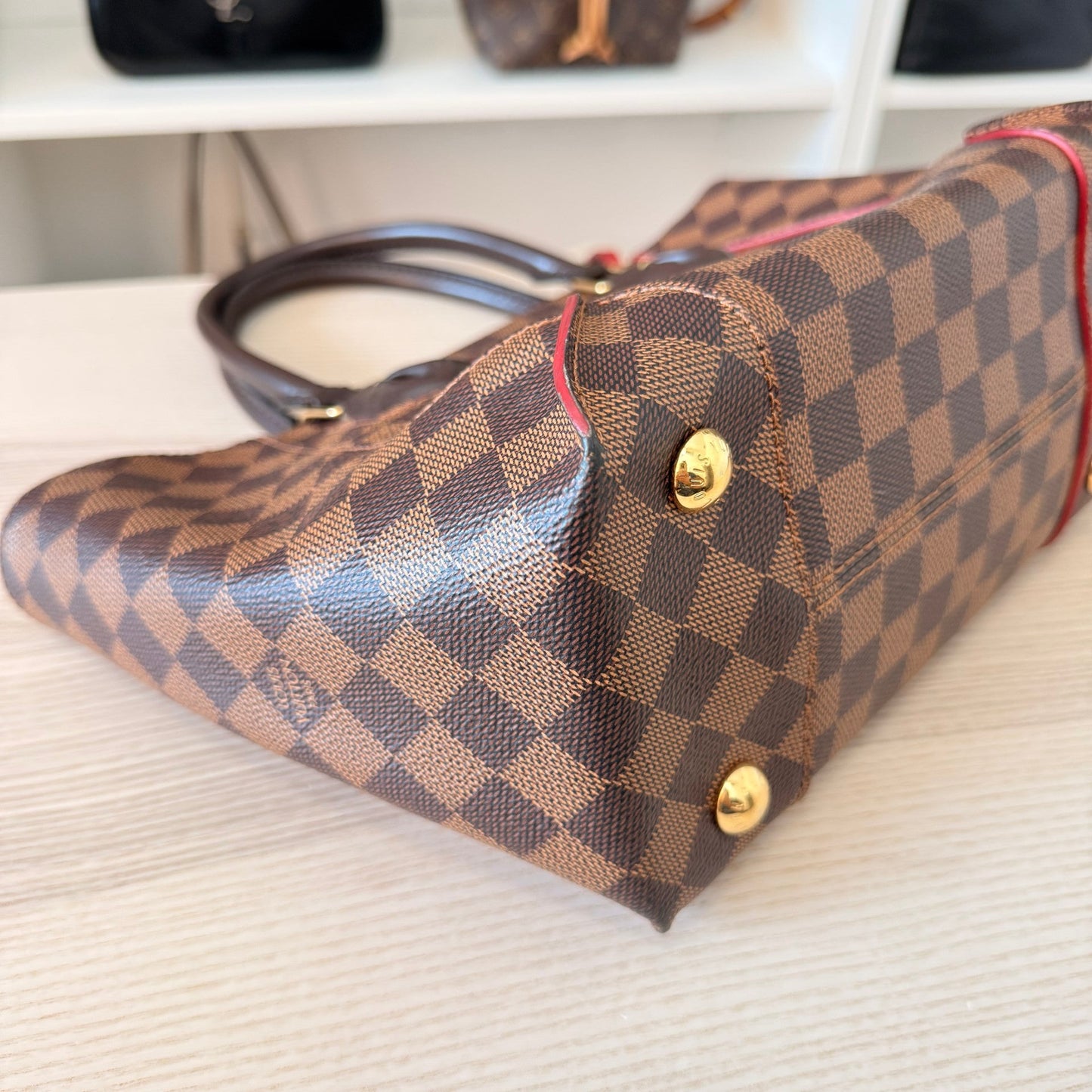 Luxe Vault preowned Louis Vuitton Caissa PM handbag in Damier Ebene canvas with red trim and gold tone feet