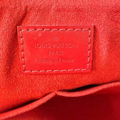 Luxe Vault interior view of a red Louis Vuitton Caissa PM bag featuring the embossed leather brand logo patch
