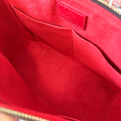 Interior of Luxe Vault Louis Vuitton Caissa PM bag featuring vibrant red microfiber lining and leather brand patch