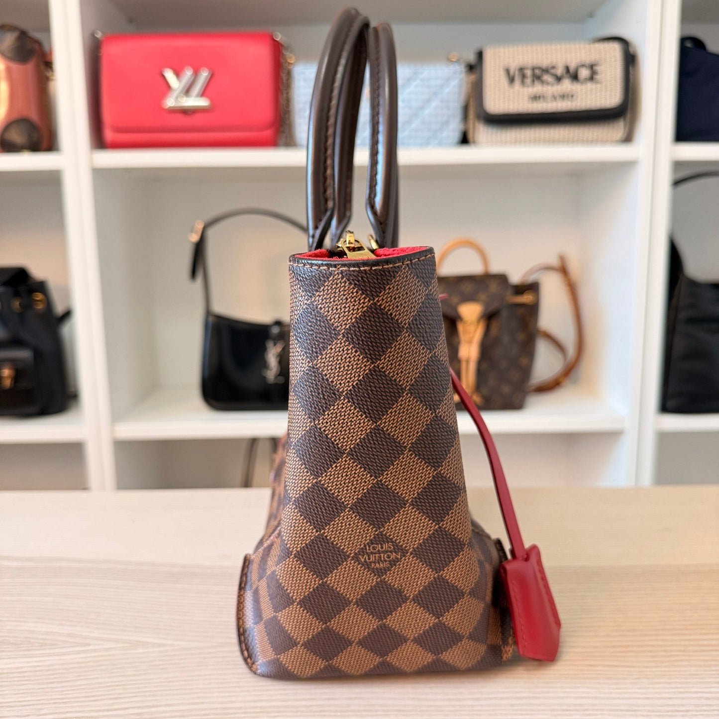Luxe Vault Louis Vuitton Caissa PM handbag in Damier Ebene canvas with red leather accents, side profile view