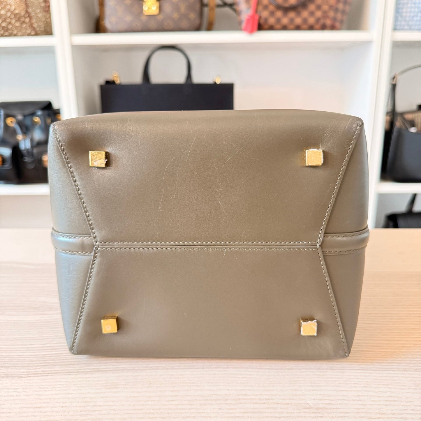 Luxe Vault Saint Laurent Le 37 bucket bag in deep musk shiny calfskin showing the base with protective gold feet