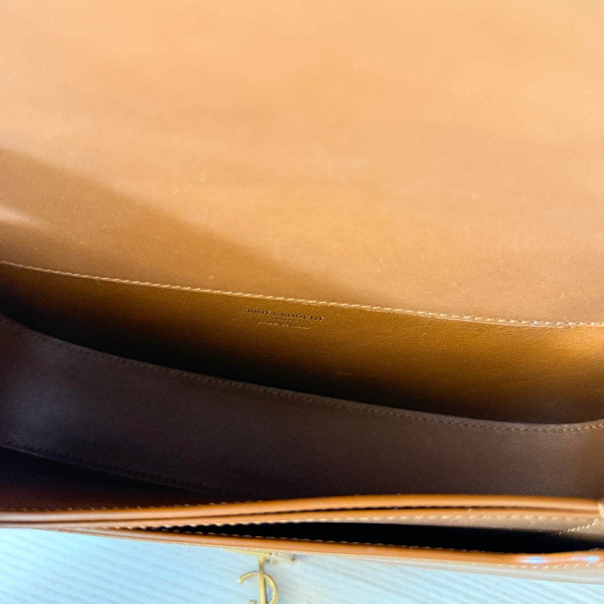 Interior of Luxe Vault Saint Laurent Voltaire shoulder bag in brown leather showing the brand logo stamp